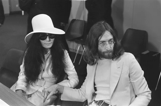 1091px-John_Lennon_en_echtgenote_Yoko_Ono_vertrekken_van_Schiphol_naar_Wenen_in_de_vert,_Bestanddeelnr_922-2499 one-to-one-john-&-yoko